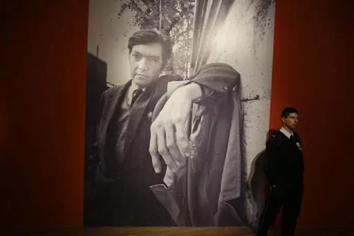 A security guard stands near a large photo of late writer Julio Cortazar at an exhibit marking the 100-year anniversary of his birth at the National Museum of Fine Arts in Buenos Aires, Argentina, Aug. 26, 2014. A bundle of 60-year-old pages of Cortazar´s writings was sold at auction on Thursday, October 12, 2023, by the Zorrilla de Montevideo auction house. (AP Photo/Victor R. Caivano, File)