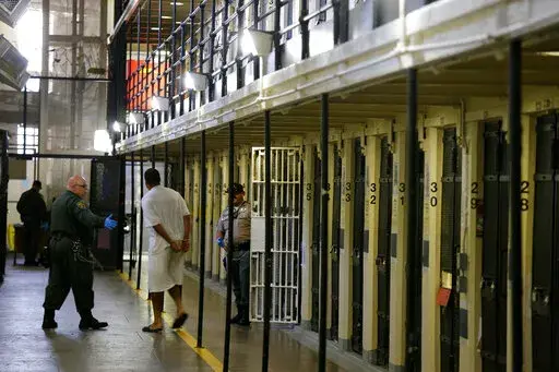 In this Aug. 16, 2016, file photo a condemned inmate is led out of his east block cell on death row at San Quentin State Prison, in San Quentin, Calif. California Gov. Gavin Newsom is moving to dismantle the nation's largest death row by moving all condemned inmates to other prisons with in two years. The goal is to turn the section of San Quentin State Prison into "a positive, healing environment." (AP Photo/Eric Risberg, File)