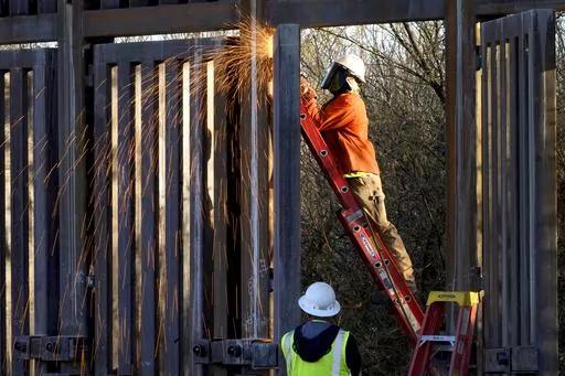 Crews construct a section of border wall in San Bernardino National Wildlife Refuge, Tuesday, Dec. 8, 2020, in Douglas, Ariz. Construction of the wall along the U.S.-Mexico border under former President Donald Trump toppled untold numbers of saguaro cactuses in Arizona, put endangered ocelots at risk in Texas and disturbed Native American burial grounds, Congress' official watchdog said Thursday, Sept. 7, 2023. (AP Photo/Matt York, File)