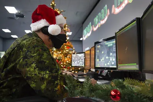 In this photo provided by the North American Aerospace Defense Command, a 22 Wing member is seen showing how they track Santa on his sleigh on Christmas evening during a media preview at the Canadian Forces Base in North Bay on Dec. 9, 2021. In a Christmas Eve tradition going on its 66th year, a wildly popular program run by the U.S. and Canadian militaries is providing real-time updates on Santa's progress around the globe -- and fielding calls from children who want to know St. Nick's exact wh