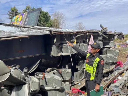 An investigator inspects the accident site where a bus travelling from northern Thailand overturned in eastern Prachinburi province, killing multiple people on Wednesday Feb 26, 2025. (Department of Land Transport via AP)