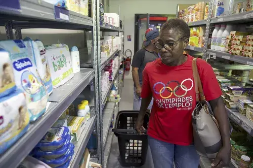 Jeanne Musaga shops at a social group store, Tuesday, Aug. 6, 2024, during the 2024 Summer Olympics, in Epinay-sur-Seine, France. (AP Photo/Nicolas Garriga)