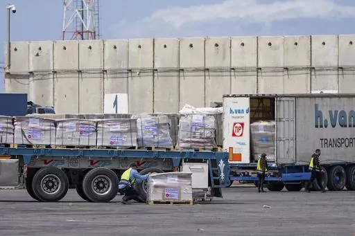 Trucks carrying humanitarian aid for the Gaza Strip pass through the inspection area at the Kerem Shalom Crossing in southern Israel, Thursday, March 14, 2024. (AP Photo/Ohad Zwigenberg)