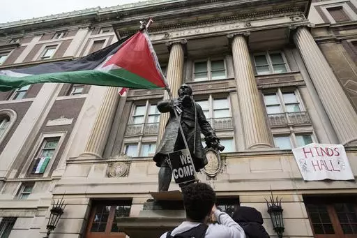 A student protester parades a Palestinian flag outside the entrance to Hamilton Hall on the campus of Columbia University, Tuesday, April 30, 2024, in New York. The student-run legal journal, Columbia Law Review, was taken offline Monday, June 3, 2024, after its board of directors objected to the publication of an article that accused Israel of genocide. (AP Photo/Mary Altaffer, Pool, File)