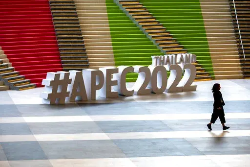 A participant runs past signage at the venue of the Asia-Pacific Economic Cooperation APEC summit venue, Friday, Nov. 18, 2022, in Bangkok, Thailand. (AP Photo/Anupam Nath)