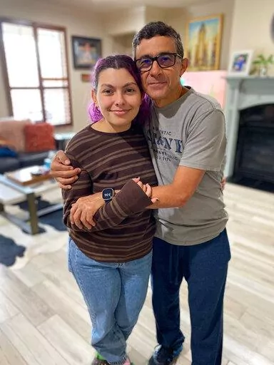 In this handout photo provided by Maria Elena, Gustavo Cardenas, one of six oil executives jailed in Venezuela, poses for a photo with his daughter Maria Mercedes, in their home in Houston, Wednesday, March 9, 2022. Cardenas expressed happiness to be home after an imprisonment of more than four years that he said “has caused a lot of suffering and pain, much more than I can explain with my words.” But he said he is praying for five colleagues of his company who were not released Tuesday nigh