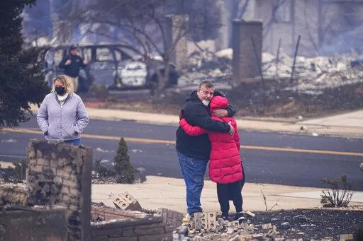 Renato D'Amario hugs neighbor Lori Peer after finding their homes destroyed, Friday, Dec. 31, 2021, in Louisville, Colo., after wildfires swept through the day before. (AP Photo/Jack Dempsey)