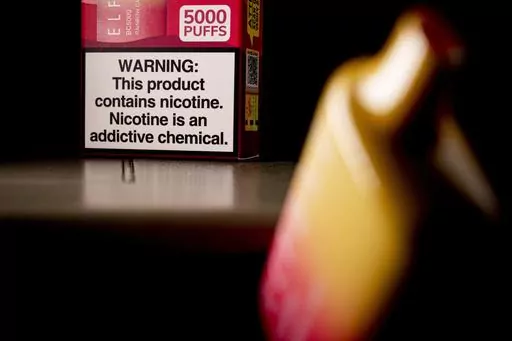 A health warning is seen on the packaging of a disposable vaping pod device in Washington on Monday, June 26, 2023. Sixty years ago, the U.S. surgeon general released a report that settled a longstanding public debate about the dangers of cigarettes and led to huge changes in smoking in America. Some public health experts say a similar report could help clear the air about vaping.(AP Photo/Andrew Harnik, File)
