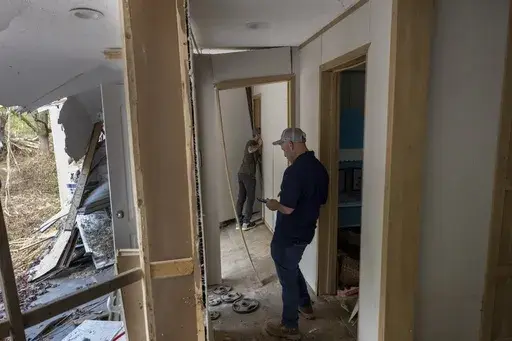 FEMA employee Jirau Alvaro works with Daniel Mancini, doing a report on the damage to his property on Sunday, Oct. 6, 2024 in rural Buncombe County, near Black Mountain, N.C. (Robert Willett/The News & Observer via AP)