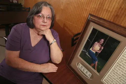 Wanda Farris sits beside a picture of her daughter, 16-year-old Leesa Gray, that hangs inside Comer's Restaurant in Dorsey Miss., Thursday Dec. 8, 2022. Gray was kidnapped, raped and murdered by death row inmate Eddie Loden in the summer of 2000. Loden will be put to death by the state of Mississippi on Wednesday. (Thomas Wells/The Northeast Mississippi Daily Journal via AP)