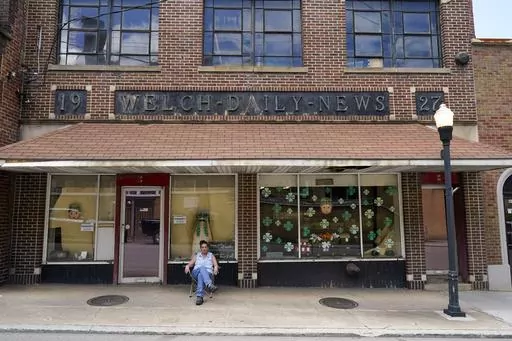 Missy Nester owner of the The Welch News sits in front of the now closed office on Wednesday, May 31, 2023, in Welch, W.Va. In March, the weekly publication in McDowell County one of the poorest counties America became another one of the quarter of all U.S. newspapers that have shuttered since 2005, a crisis Nester called "terrifying for democracy" and one that disproportionately impacts rural America. (AP Photo/Chris Carlson)