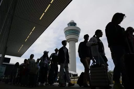 Travelers wait in long lines outside the terminal building to check in and board flights at Amsterdam's Schiphol Airport, Netherlands, on June 21, 2022. A judge ruled Wednesday April 5, 2023 that the Dutch government cannot order Amsterdam's Schiphol Airport, one of Europe's busiest aviation hubs, to reduce the number of flights from 500,000 per year to 460,000, dealing a blow to efforts to cut emissions and noise pollution.(AP Photo/Peter Dejong, File)