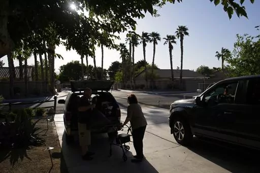Maria Jackson, right, moves into a room at a home with the help of friend David Mcfarlan Monday, May 8, 2023, in Las Vegas. Jackson, a longtime massage therapist, lost her customers when the pandemic triggered a statewide shutdown in March 2020 and was evicted from her apartment earlier this year. (AP Photo/John Locher)