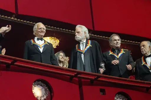 2024 Kennedy Center Honorees from the band the Grateful Dead, from left, Billy Kreutzmann, Bobby Weir, and Mickey Hart are announced at the start of the Kennedy Center Honors Gala, Sunday, Dec. 8, 2024, in Washington. At right is fellow Honoree Francis Ford Coppola. (AP Photo/Kevin Wolf)