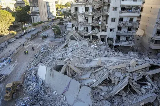 Rescue workers use a bulldozer to remove rubble of destroyed buildings at the site of an Israeli airstrike that hit several branches of the Hezbollah-run Qard al-Hassan Association in Beirut's southern suburb, Lebanon, Oct. 21, 2024. (AP Photo/Hassan Ammar, File)
