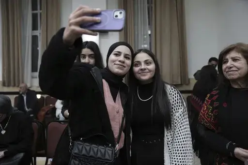 Dania Hanatsheh, right, a former Palestinian prisoner who was released from an Israeli prison as part of a ceasefire deal between Israel and Hamas, poses for a photo at a reception for released prisoners, West Bank city of Ramallah, Monday, Jan. 20, 2025. (AP Photo/Mahmoud Illean)