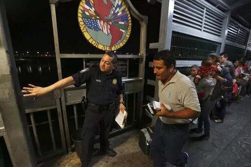  In this Sept. 17, 2019 photo, a U.S. border patrol officer directs a Nicaraguan migrant family, who is applying for asylum in the U.S., over International Bridge 1 from Nuevo Laredo, Mexico into Laredo, Texas, for an interview with immigration officials. The Biden administration has begun expelling Cubans and Nicaraguans to Mexico under pandemic-related powers to deny migrants a chance to seek asylum, expanding use of the rule even as it publicly says it has been trying to unwind it, officials 
