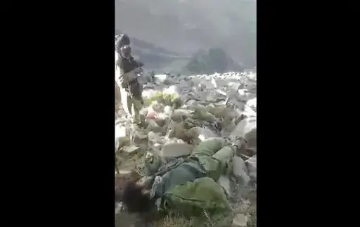 In this frame grab from video that was likely taken by the Taliban and posted online and provided by Afghan Witness, a UK-based open-source nonprofit, a Taliban fighter stands amid bodies on the ground, in the Dara district, of Panjshir province, Afghanistan, Sept. 14, 2022. The Taliban captured, bound and shot to death 27 men in Afghanistan’s Panjshir Valley last month during an offensive against resistance fighters in the area, according to a new report by Afghan Witness published Tuesday, O