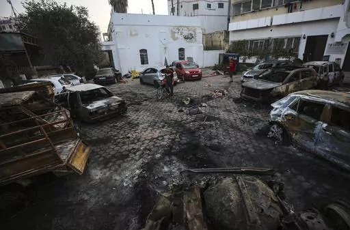 Palestinian men look over the site of a deadly explosion at al-Ahli Hospital in Gaza City, Wednesday, Oct. 18, 2023. (AP Photo/Abed Khaled)