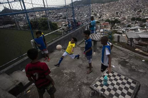 Youths play soccer as they wait for a street soccer training program run by the Street Child United Brazil non-governmental organization, at the Complexo da Penha favela, in Rio de Janeiro, Brazil, April 29, 2023. After decades of delay and pressure, Brazil announced on Jan. 23, 204 that it will henceforth use “favelas and urban communities” to categorize thousands of poor, urban neighborhoods, instead of the previous term “subnormal agglomerates” that was widely viewed as stigmatizing. 
