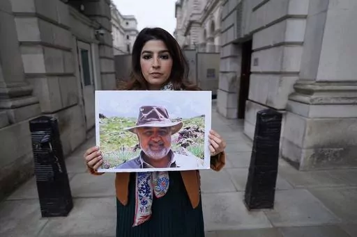 Roxanne Tahbaz holds a picture of her father Morad Tahbaz who is jailed in Iran, during a protest outside the Foreign, Commonwealth and Development Office in London, April 13, 2022. Iran has transferred five Iranian-Americans from prison, identifying three of the prisoners as Siamak Namazi, Emad Shargi, and Morad Tahbaz, to house arrest. The move comes after Tehran has spent months suggesting a prisoner swap with Washington. (Stefan Rousseau/PA via AP, File)