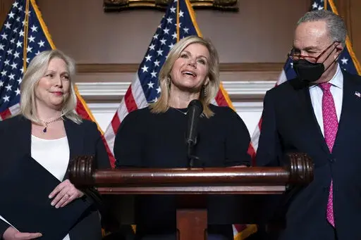 Former Fox News anchor Gretchen Carlson, center, celebrates with Sen. Kirsten Gillibrand, D-N.Y., left, and Senate Majority Leader Chuck Schumer, D-N.Y., after Congress gave final approval to legislation guaranteeing that people who experience sexual harassment at work can seek recourse in the courts, during a news conference at the Capitol in Washington, Thursday, Feb. 10, 2022. Since her 2016 sexual harassment lawsuit against then Fox News Chairman and CEO Roger Ailes, Carlson has worked to ba
