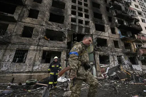 Ukrainian soldiers and firefighters search in a destroyed building after a bombing attack in Kyiv, Ukraine, Monday, March 14, 2022. (AP Photo/Vadim Ghirda, File)