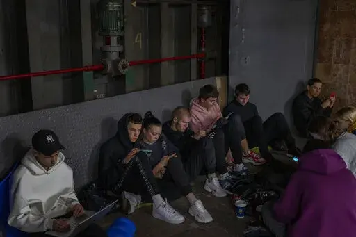 People sit in the Kyiv subway, using it as a bomb shelter, in Kyiv, Ukraine, on Wednesday, Oct. 19, 2022. (AP Photo/Emilio Morenatti)