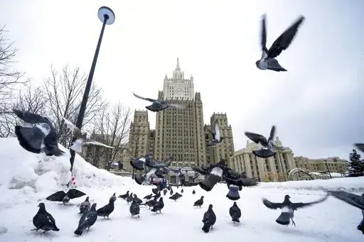 Pigeons take off in front of the Russian Foreign Ministry building in Moscow, Russia, Wednesday, Jan. 26, 2022. Russian Foreign Minister Sergey Lavrov said he and other top officials will advise President Vladimir Putin on the next steps after receiving written replies from the United States to the demands. Those answers are expected this week — even though the U.S. and its allies have already made clear they will reject the top Russian demands. (AP Photo/Alexander Zemlianichenko)