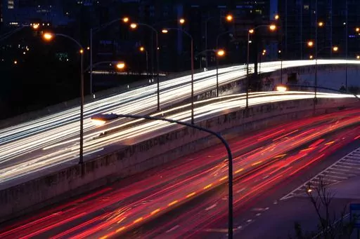 In this image made with a long exposure, motorists move along Interstate 76 ahead of the Thanksgiving Day holiday in Philadelphia, Nov. 22, 2023. U.S. inflation ticked down again last month, with cheaper gas helping further lighten the weight of consumer price increases in the United States. (AP Photo/Matt Rourke, File)