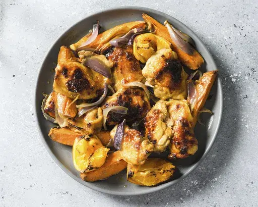 This image released by Milk Street shows a recipe for smoky chicken and sweet potato traybake. (Milk Street via AP)