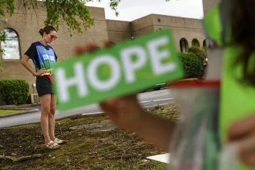 Planned Parenthood advocacy programs manager, Allison Terracio, left, stands outside the clinic to escort patients showing up for abortion appointments as Valerie Berry, program manager for the anti-abortion group, A Moment of Hope, holds up a sign at the entrance in Columbia, S.C., Friday, May 27, 2022. After decades of tiny steps and endless setbacks, America's anti-abortion movement is poised for the possibility of a massive leap. With the Supreme Court due to deliver a landmark ruling expect