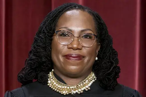 Associate Justice Ketanji Brown Jackson stands as she and members of the Supreme Court pose for a new group portrait following her addition, at the Supreme Court building in Washington, Oct. 7, 2022. (AP Photo/J. Scott Applewhite, File )DCSA122
