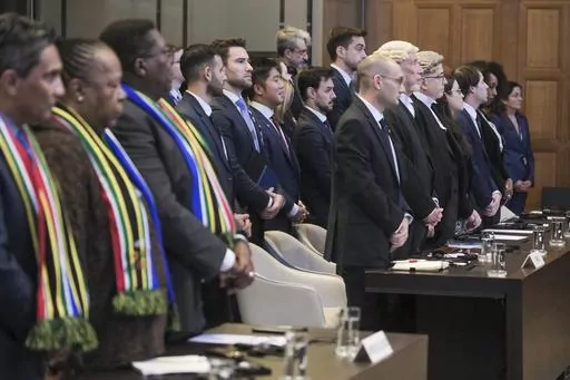 South African, left, and Israel's delegation, right, stand during session at the International Court of Justice, or World Court, in The Hague, Netherlands, Friday, Jan. 26, 2024. Israel is set to hear whether the United Nations' top court will order it to end its military offensive in Gaza during a case filed by South Africa accusing Israel of genocide. (AP Photo/Patrick Post)