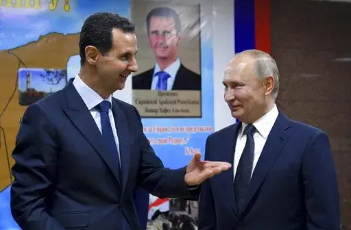 Syrian President Bashar Assad, left, gestures while speaking to Russian President Vladimir Putin during their meeting in Damascus, Syria, Tuesday, Jan. 7, 2020. With its war on Ukraine now in its third week, Putin on Friday, March 11, 2022, approved bringing in volunteer fighters from the Middle East into the conflict.  (Alexei Druzhinin, Sputnik, Kremlin Pool Photo via AP, File)