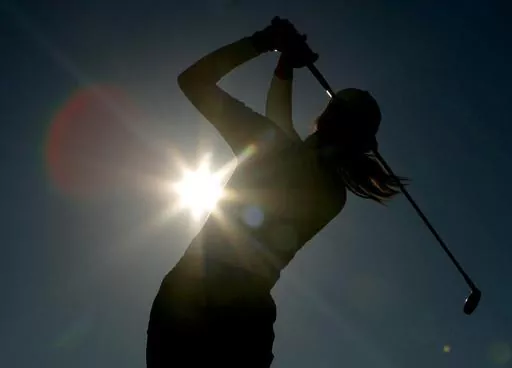 A golfer is silhouetted against the sun while teeing off on the third hole during the first round of the Women's British Open golf tournament at Royal Lytham and St Annes golf course in Lytham, north west England Thursday, Aug. 3, 2006. Kerry Bowie's daughters have dreams. Big ones. “There are some things people miss out on by not doing it,” Bowie says. “To be that young lady who plays golf, it changes things.” (AP Photo/Matt Dunham, File)