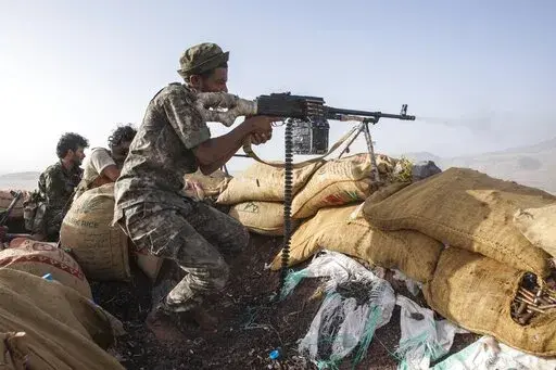 A Yemeni fighter backed by the Saudi-led coalition fires his weapon during clashes with Houthi rebels on the Kassara frontline near Marib, Yemen, Sunday, June 20, 2021. In January 2022, Yemen’s rebels have launched attacks with missiles and drones on the United Arab Emirates, a major escalation for one of the world’s most protracted conflicts. (AP Photo/Nariman El-Mofty, File)