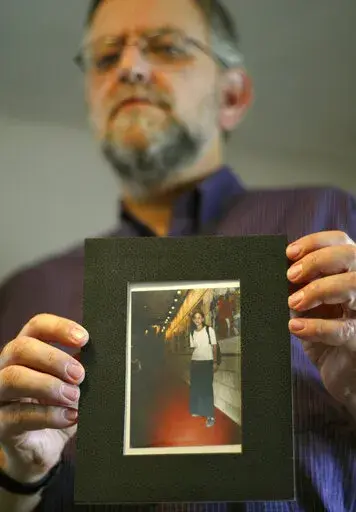 Arnold Roth holds a photo of his 15-year-old daughter Malki, who was killed in an August 2001 Palestinian suicide bombing at a Jerusalem pizzeria, at his house in Jerusalem, on Sept. 28, 2004. The family of an Israel-American girl killed in a 2001 Palestinian suicide bombing in Jerusalem is seeking a meeting with President Joe Biden in hopes of forcing Jordan to extradite Tamimi, who was convicted in the deadly attack. The parents of Malki Roth sent a letter to the White House on Sunday, July 10