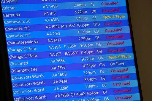 The arrivals board at the American Airlines terminal at LaGuardia Airport displays the flights that have been canceled or delayed and one that is on time, March 21, 2020, in New York. Flight delays and cancellations have bedeviled airline travel so far this year. The Transportation Department is launching a customer service dashboard to assist vacationers ahead of the travel-heavy Labor Day weekend. (AP Photo/Mary Altaffer, File)