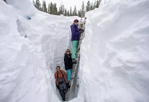 Working inside a nearly 18-foot-deep snow pit at the UC Berkeley Central Sierra Snow Lab, from left, Shaun Joseph, Claudia Norman, Helena Middleton take measurements of snow temperatures ahead of a weather storm on March 9, 2023, in Soda Springs, Calif. A new study finds the snow deluge in California, which quickly erased a two decade long megadrought, was essentially a once-in-a-lifetime rescue from above. The study authors coined the term “snow deluge” for one-in-20-year heavy snowfalls. (