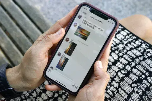 Sha Zhu, of Washington, shows the app WeChat on her phone, which she uses to keep in touch with family and friends in the U.S. and China, Tuesday Aug. 18, 2020, in Washington.  For months, the Elon Musk has expressed interest in creating his own version of China’s WeChat — a “super app” that does video chats, messaging, streaming and payments — for the rest of the world.. At least, that is, once he's done buying Twitter after months of legal infighting over the $44 billion purchase agr