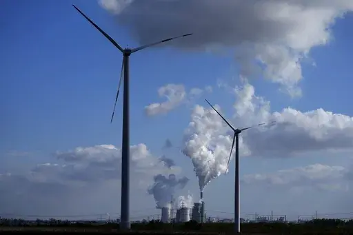 The Schkopau coal-fired power plant operates near wind turbines in Teutschenthal, near Halle, eastern Germany, Oct. 15, 2024. (AP Photo/Matthias Schrader, File)