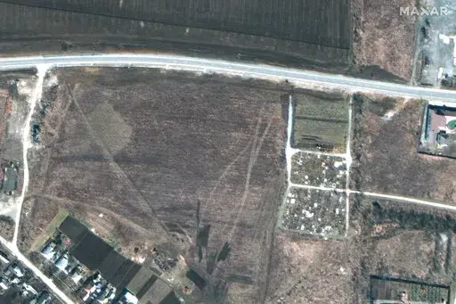 This satellite image provided by Maxar Technologies on Thursday, April 21, 2022 shows an overview of the cemetery in Manhush, some 20 kilometers west of Mariupol, Ukraine, on March 19, 2022. (Satellite image ©2022 Maxar Technologies via AP)