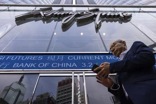 A pedestrian passes by the Hong Kong Stock Exchange electronic screen in Hong Kong, Tuesday, April 18, 2023. Asian shares were trading mixed Tuesday as pessimism about global uncertainties remained even as China reported a better-than-expected economic growth data. (AP Photo/Louise Delmotte)