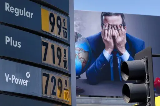 Gas prices are seen in front of a billboard advertising HBO's Last Week Tonight in Los Angeles, March 7, 2022. Three oil regimes that President Joe Biden and past U.S. leaders have snubbed — Venezuela, Saudi Arabia and Iran — are the targets of U.S. outreach as global fuel prices hit record highs during the Ukraine crisis. But it’s not clear any U.S. diplomacy could get more crude on the market fast enough to help the current supply crunch. (AP Photo/Jae C. Hong, File)