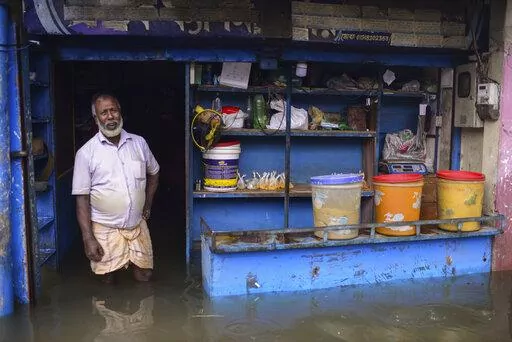 A man stands at the doorway of his flooded shop in Sylhet, Bangladesh, Monday, June 20, 2022. Floods in Bangladesh continued to wreak havoc Monday with authorities struggling to ferry drinking water and  dry food to flood shelters across the country’s vast northern and northeastern regions. (AP Photo/Mahmud Hossain Opu)