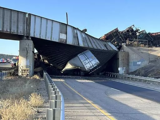 This image provided by the Colorado State Patrol shows a truck caught under a bridge that collapsed during a train derailment across a major highway near Pueblo, Colo., Sunday, Oct. 15, 2023. The main north-south highway in Colorado remained closed Monday morning and the Colorado Department of Transportation said it expected an "extended closure." The truck driver was initially said to be trapped in the Sunday afternoon accident along Interstate 25, but authorities said Monday that he had died. 