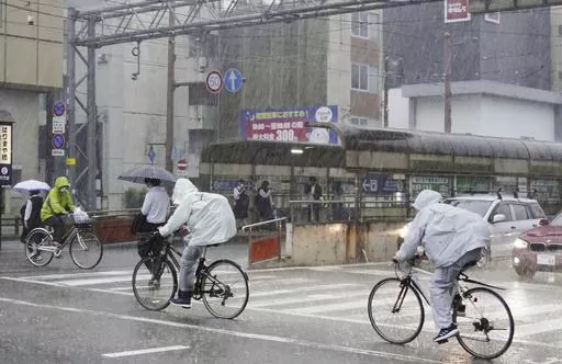 People make their way in a strong rain in Kochi, southern Japan Friday, June 2, 2023. A weakened Tropical Storm Mawar brought heavy rains to Japan’s main southern islands Friday after passing the Okinawan archipelago and causing injuries to several people. (Kyodo News via AP)