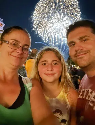 In this image provided by Jennifer Travis, the Travis family, from left, Jennifer, Aubry and Travis pose at Walt Disney World in Orlando, Fla., on Aug. 20, 2021. The  family were among hundreds of motorists who waited desperately for help Tuesday, Jan. 4, 2021, after the winter storm snarled traffic and left some drivers stranded for nearly 24 hours along an impassable stretch of Interstate 95 south of the nation’s capital. (Jennifer Travis via AP)