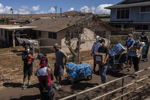 Volunteers make food, bottle water and supply deliveries to elderly residents impacted by a devastating wildfire in Lahaina, Hawaii, Aug. 19, 2023. Residents of Maui are eager to learn when they can expect safe drinking water to be restored in the wake of last month’s catastrophic wildfires, but extensive testing is still needed and officials are urging patience. (AP Photo/Jae C. Hong, File)